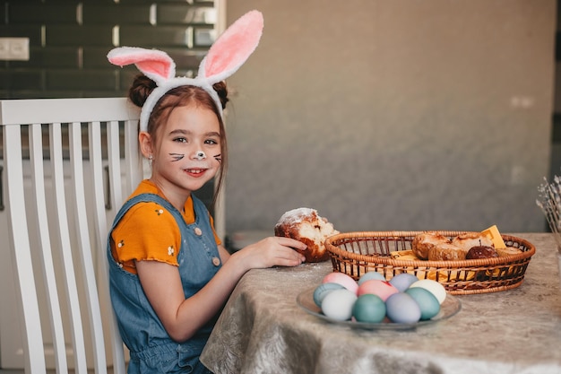 Beautiful girl in bunny ears paint easter eggs