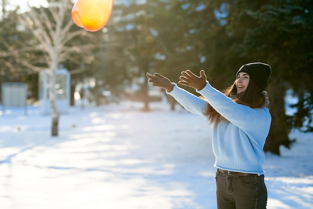 Beautiful girl catches a balloon in the shape of a heart, Valentine's Day