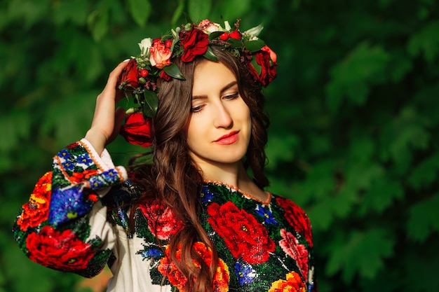 Beautiful girl in colorful ukrainian traditional cloth with wreath