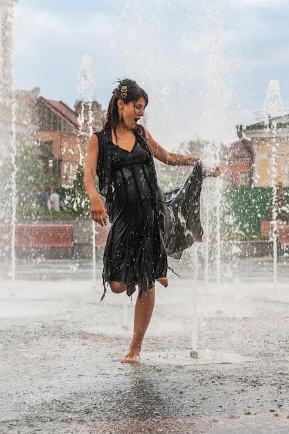 Beautiful girl dances in a fountain