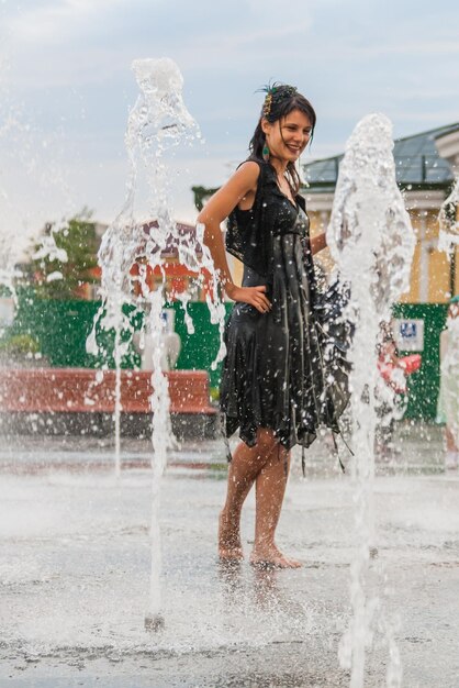 Beautiful girl dances in a fountain