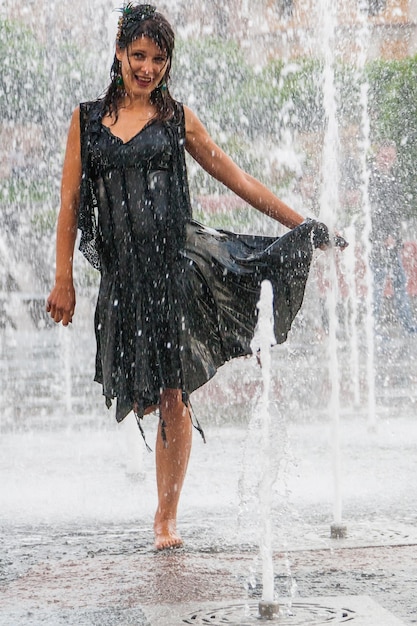 Beautiful girl dances in a fountain