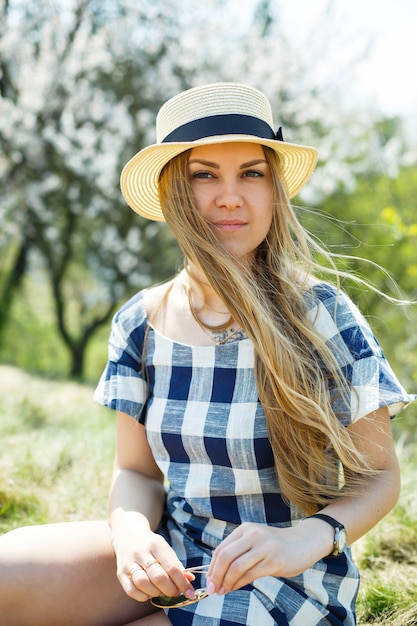 Beautiful girl in a dress walking in the spring forest where the trees bloom