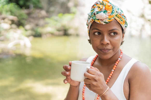 Beautiful girl drinking coffee in the forest