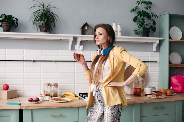 Beautiful girl drinking juice at home in morning