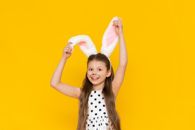 A beautiful girl in an Easter bunny costume points at the advertisement and smiles