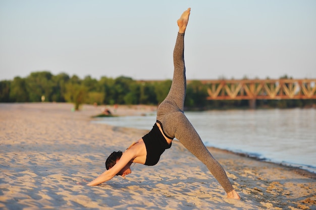 Beautiful girl engaged in yoga on the beach in spring