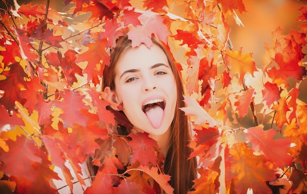 Beautiful girl enjoying autumn Young woman with tongue and funny autumn mood