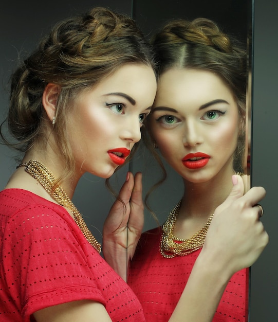 Beautiful girl female model with bright makeup and her reflect