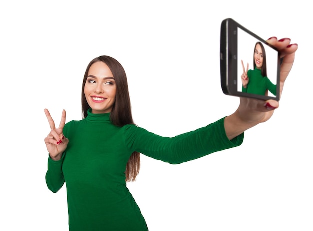 Beautiful girl in a green turtleneck photographs selfie