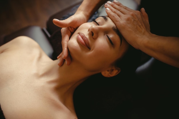 Beautiful girl has a facial massage in a beauty clinic