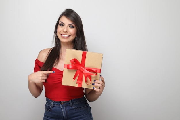 Beautiful girl holding valentine's gift on white background