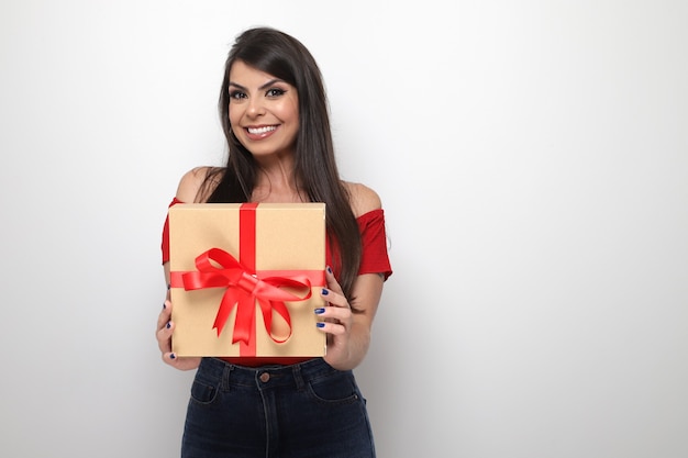 Beautiful girl holding valentine's gift on white background