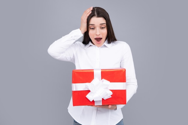 Beautiful girl holding valentines gift Happy birthday celebration woman day christmas Expressive facial expressions with suprised face Woman holding gift box and rejoices