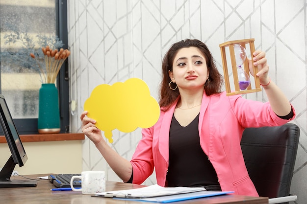 Beautiful girl holding yellow idea bubble in a cloud shape and looking at sand cloud