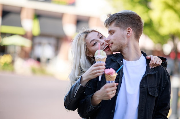 A beautiful girl hugging her boyfriend and holding ice cream