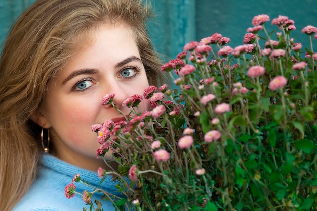 A beautiful girl is holding a large bouquet of flowers and smiling Happy young woman in the city