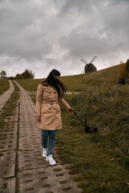 Beautiful girl is hugging her cat Concept of weekend in the countryside area with your lovely pet Brunette woman has great time with her black shorthair cat