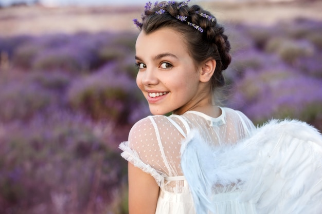 Beautiful girl in lavender wreath and retro dress on the lavender field.  Angel. Beautiful girl in the lavender field on sunset in France . Girl collect lavender.