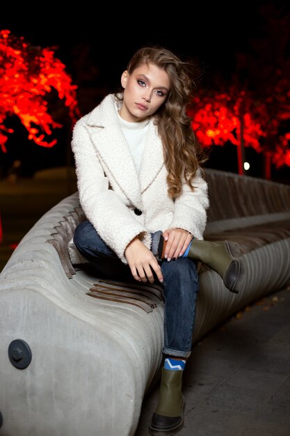 Beautiful girl at night in the park cute model on the background of the night city