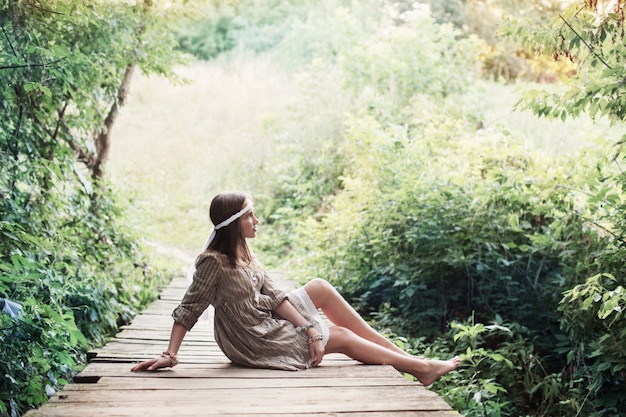 Beautiful girl on old wooden brdge in forest