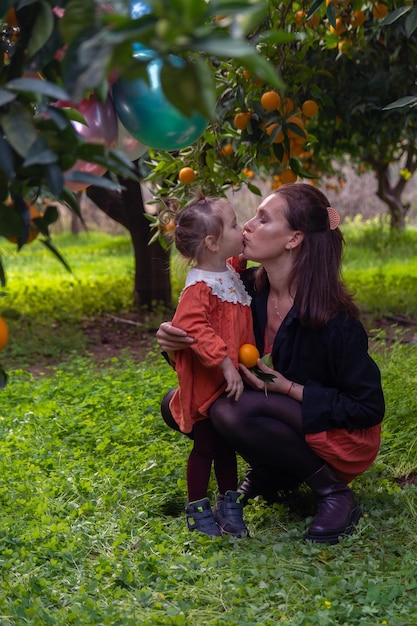 Beautiful Girl in the Orange Garden and ripe oranges on the branches of trees