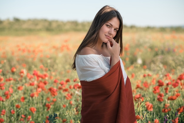 Beautiful girl in a poppy field at sunset. concept of freedom