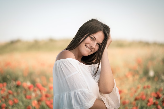 Beautiful girl in a poppy field at sunset. concept of freedom