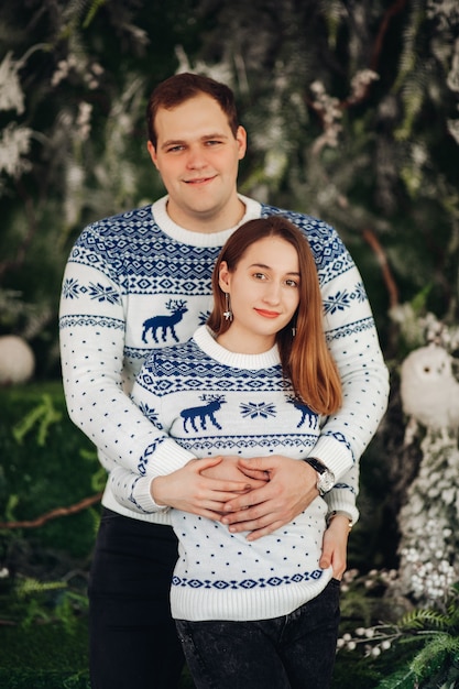 beautiful girl poses with her husband with christmas decorations