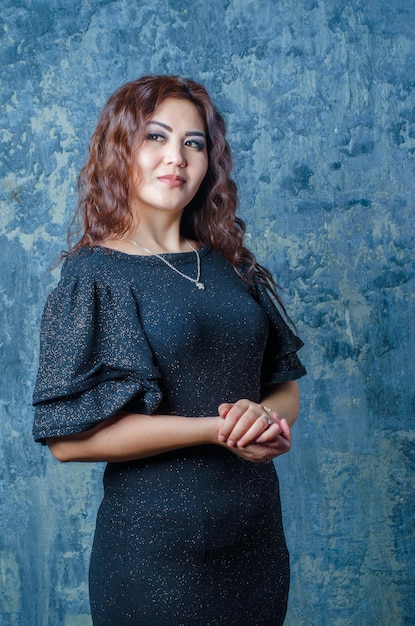 Beautiful girl posing in the studio in a dark dress