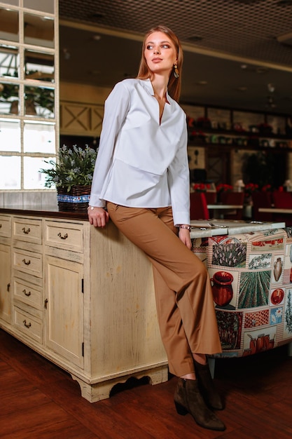 A beautiful girl showing fashionable clothes against the backdrop of the restaurant scenery Clothes for the showroom