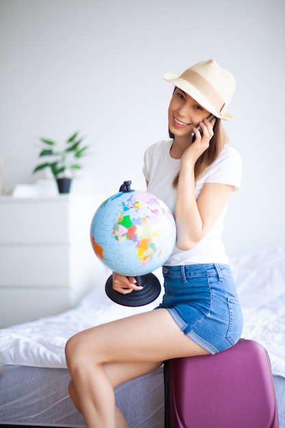 Beautiful girl sitting on the bed and goes on vacation