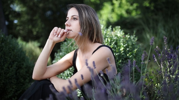 Beautiful girl sitting in a garden with lavender