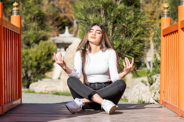 A beautiful girl sitting on the ground and doing mentation High quality photo