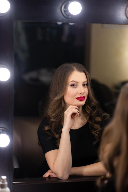 Beautiful girl smiling and looking in the mirror