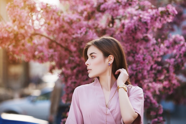 Beautiful girl in spring pink blossom