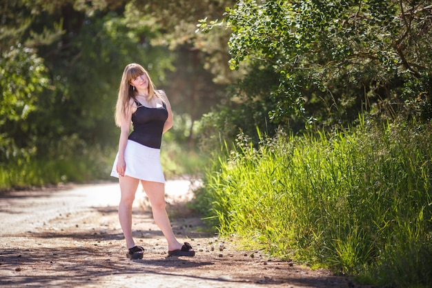 Beautiful girl stands in thicket of forest