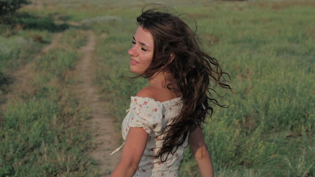 A beautiful girl in the steppe Slowmotion authentic video A beautiful young girl is circling and sincerely smiling at the camera