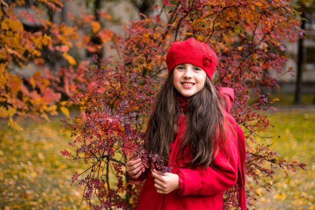 Beautiful girl in sunny autumn park Child playing in park at autumn Autumn mood High quality photo