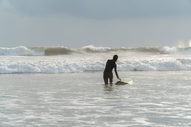 Beautiful girl on a surf board in the ocean