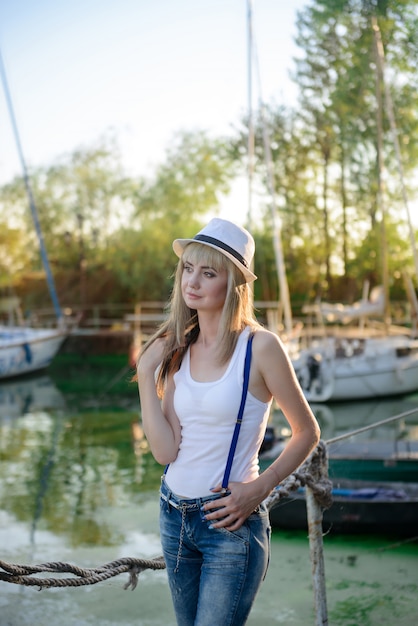 The beautiful girl on walk on the yacht club mooring