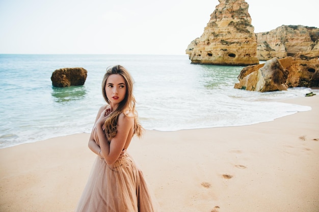 Beautiful girl walking on the beach at sunset, freedom concept