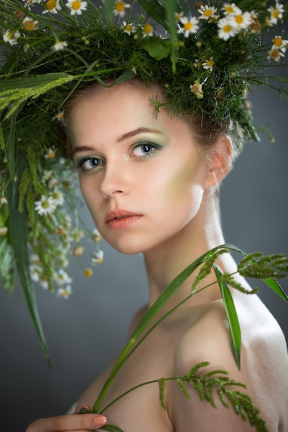 Beautiful girl wearing a wreath of wildflowers