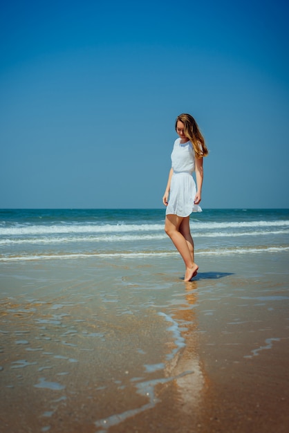 Beautiful Girl in White Dress Enjoy and Relax on The Beach