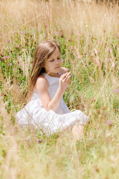 Photo beautiful girl in wildflowers on a sunny day