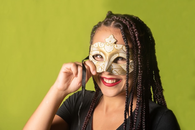 Beautiful girl with braids in her hair and carnival mask