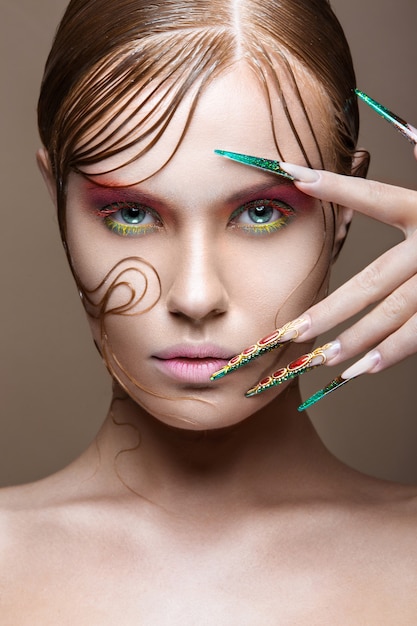 Beautiful girl with bright fashion make-up, creative hairstyle, long nails.