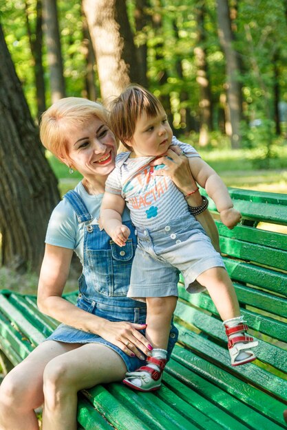 Beautiful girl with children sits on a bench in the park