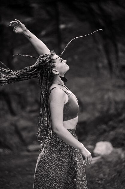 Beautiful girl with dreadlocks dressed hippie styleposes outdoors