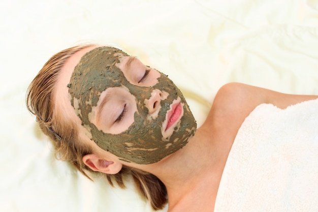 Beautiful girl with facial clay mask.